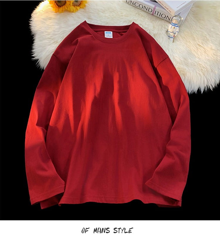 Vibrant red oversized long sleeve blank t-shirt made of soft slightly textured fabric with a relaxed fit and crewneck design.