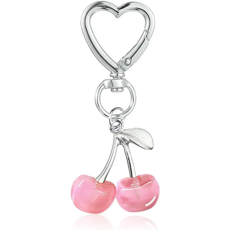 A shiny silver heart-shaped keychain with two pink glossy cherry charms dangling as a cherry bag charm heart keychain.