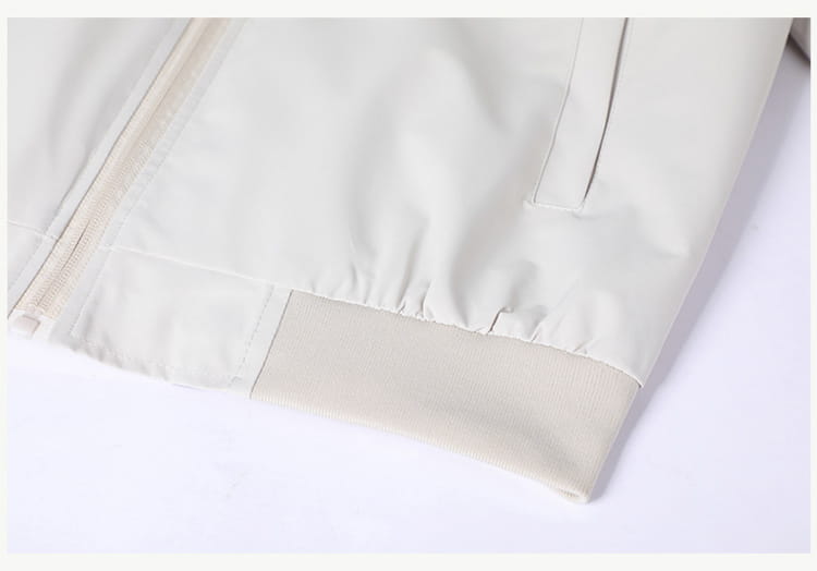 Chaqueta cortavientos ligera para hombre en nailon color beige claro, con brillo sutil y puños acanalados, con cuello vuelto.