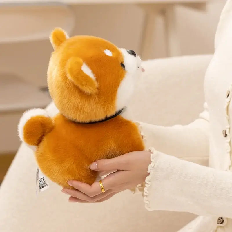 A plush shiba inu dog stuffed animal toy in orange and white with a black collar made of soft material.