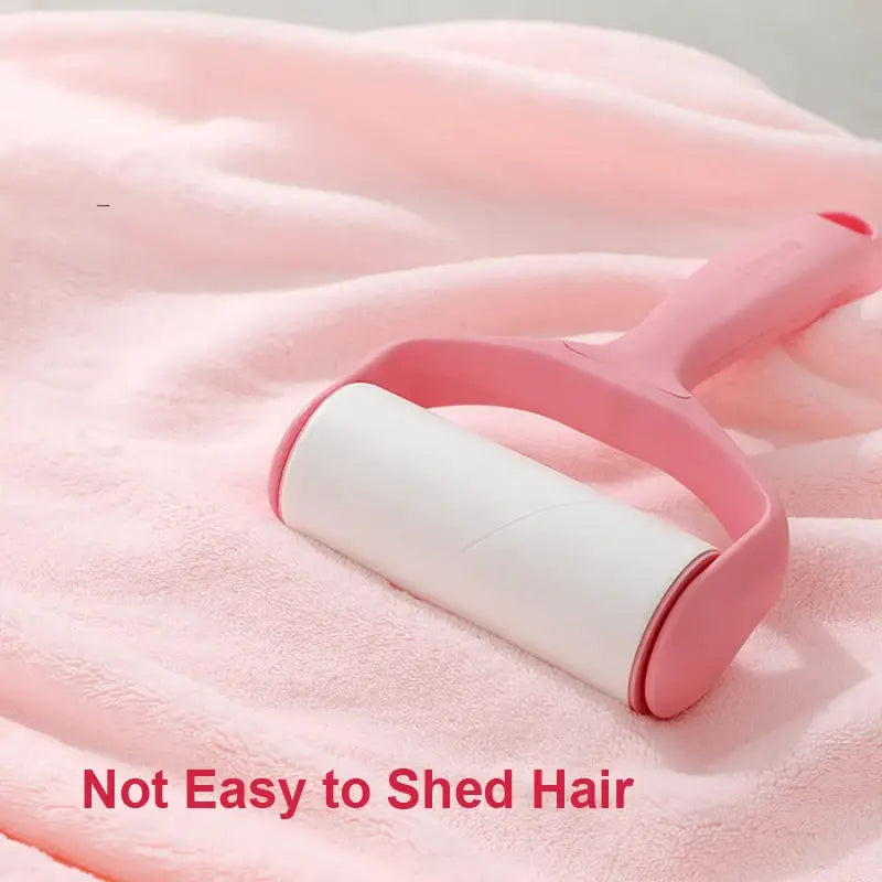 Rouleau anti-peluches à manche rose avec rouleau adhésif blanc, pour un retrait facile des poils, conçu en complément de la serviette de bain pour bébé à capuche à thème animal, afin d’assurer un entretien délicat du tissu.