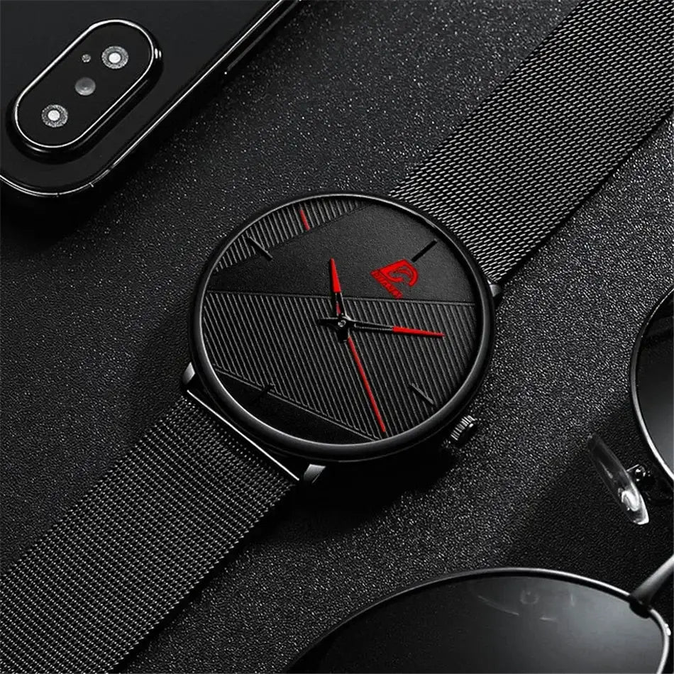 Herrenarmbanduhr aus schwarzem Mesh, Quarz, mit einem schwarzen Zifferblatt mit roten Akzenten an Zeigern und Logo sowie einem Mesh-Armband.
