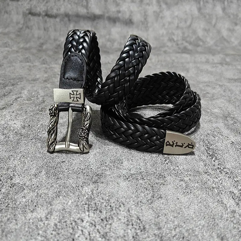 Black braided leather fashion belt male with ornate silver-toned luxury designer punk buckle featuring a cross and floral detailing.