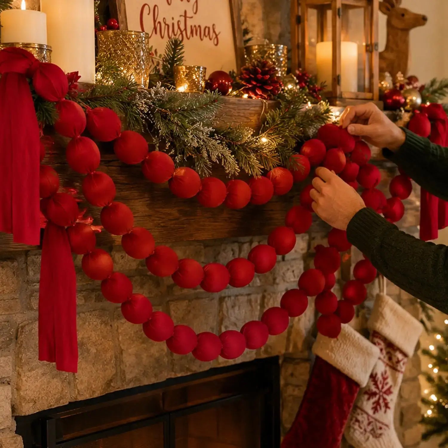 Eine burgunderfarbene Samt-Kugelgirlande, über einem steinernen Kaminaufsatz drapiert, als Weihnachtsbaum-Dekoration.