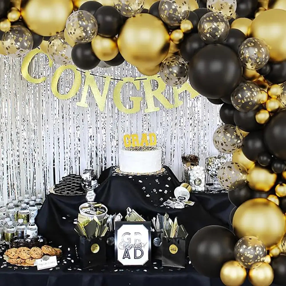 Schwarzes und goldenes Ballonbogen-Set mit mit Konfetti gefüllten Ballons und einer schimmernden silbernen Fransen-Rückwand für Partys und Feiern.