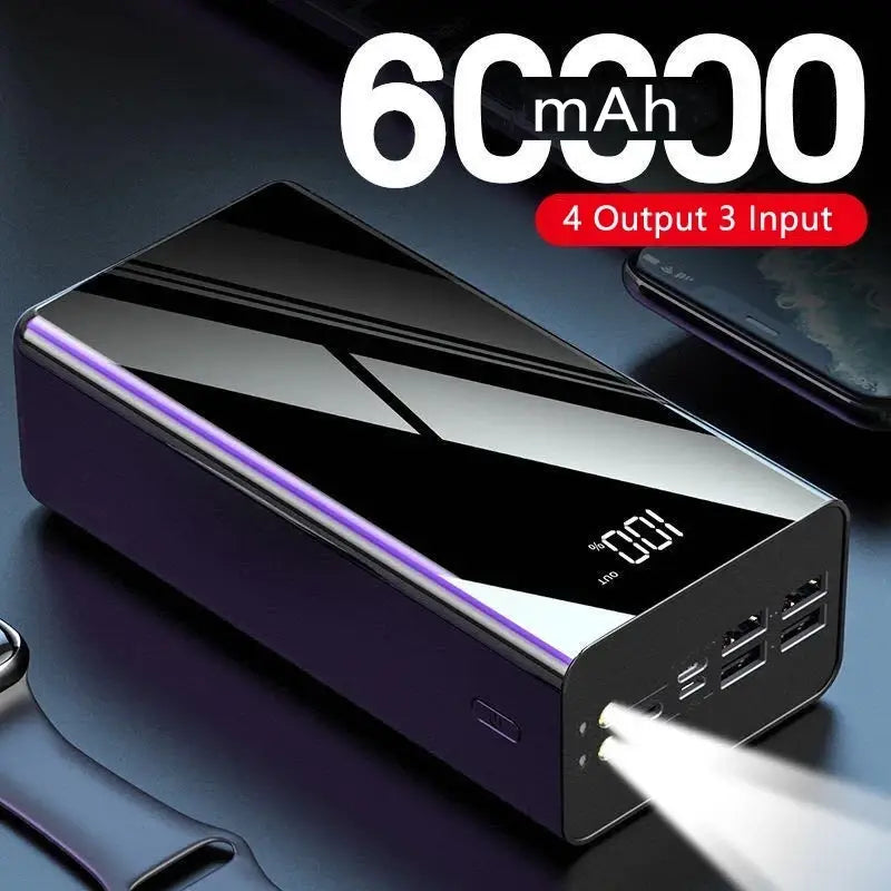 Schwarze und silberne rechteckige Powerbank mit glänzender Oberfläche, digitaler LED-Anzeige mit 100 Prozent Akkuladung und mehreren USB-Anschlüssen, kompatibel mit verschiedenen Ladegeräten, dargestellt in der Power Bank 60000 mAh Tragbaren Ladeeinheit mit LED-Anzeige.