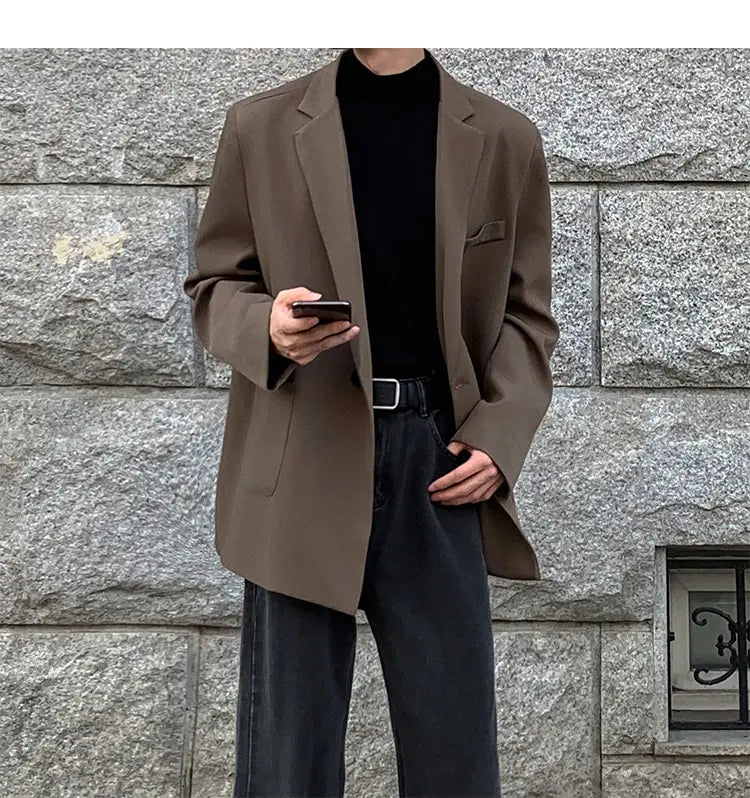 Una blazer entallada oversize de doble botonadura en poliéster marrón, con acabado mate y solapas tipo pico, para uso casual.