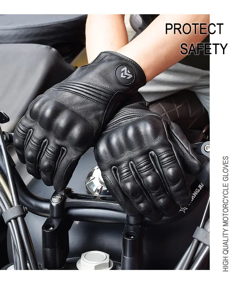 Gants de moto en cuir noir pour homme avec un matériau perforé respirant et un rembourrage renforcé des articulations, présentés côté arrière, avec un écusson à logo circulaire sur la main.