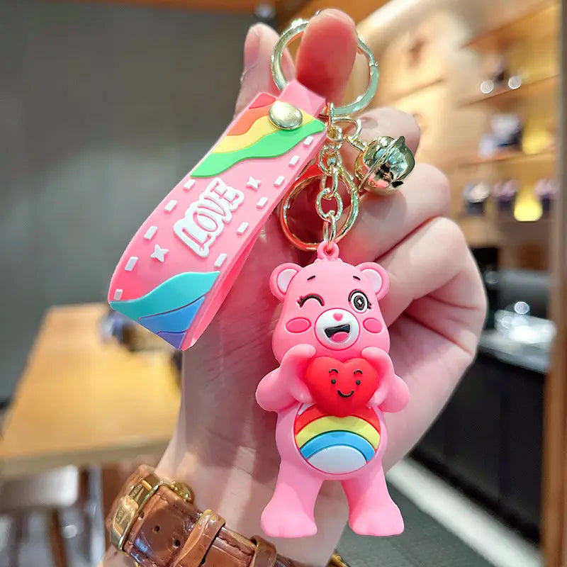 Pink care bears silicone cartoon keychain backpack pendant featuring a rainbow belly and heart design attached to a pink strap with the word love in white lettering.