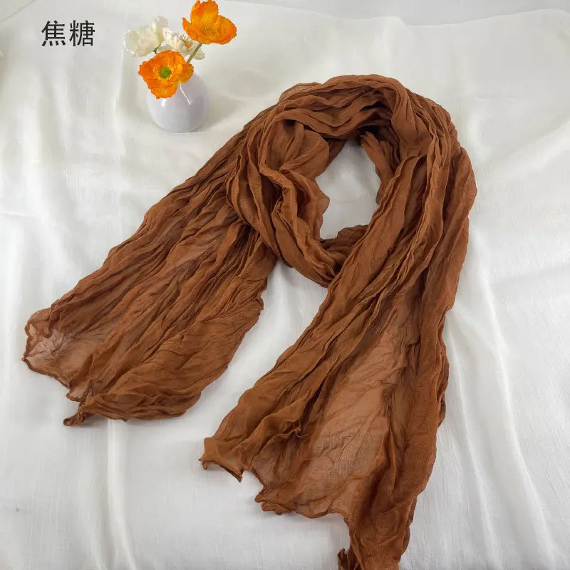 Écharpe en mousseline de chiffon caramélisée douce et froissée, au design fluide délicat, présentée comme une écharpe en coton et lin plissé.