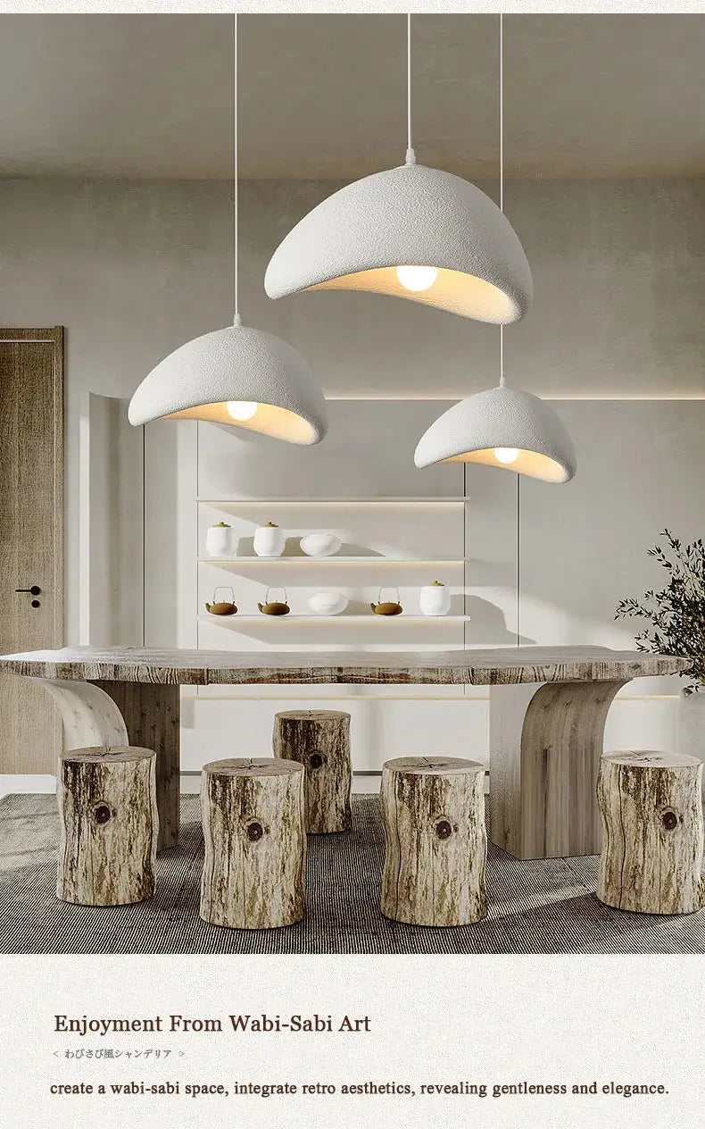 Tres luminarias colgantes blancas con una forma de cúpula curvada y texturizada, suspendidas del techo para su uso en sala o comedor.
