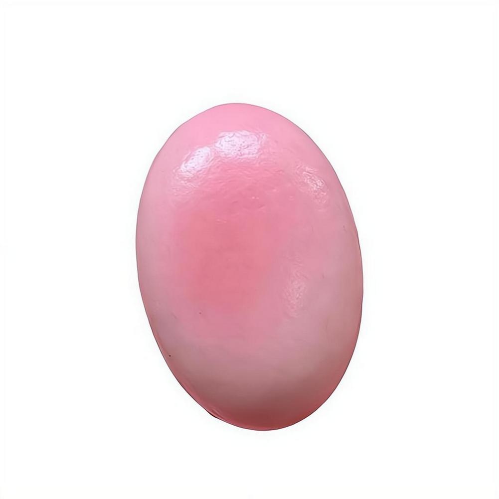 Un pastel de queso lento esponjoso y blando de forma ovalada y suave, color rosa, con acabado brillante, diseñado para aliviar el estrés.