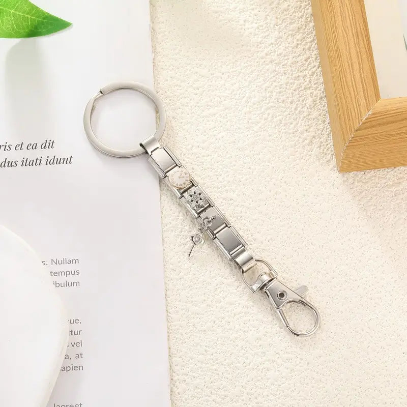 Llavero con dije de eslabones italianos de metal con acabado plateado, con un diseño modular elegante que presenta dijes decorativos florales y con aspecto de engranajes para uso personalizado en bricolaje.