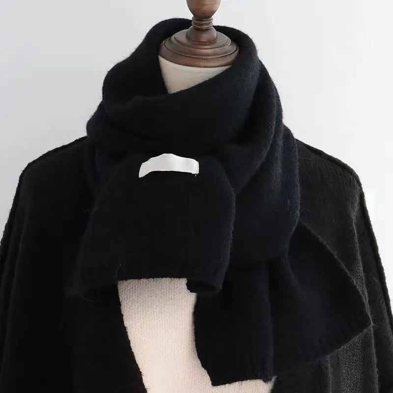 Bufanda de invierno tejida negra para hombres y mujeres con un sutil parche rectangular blanco en la parte frontal.