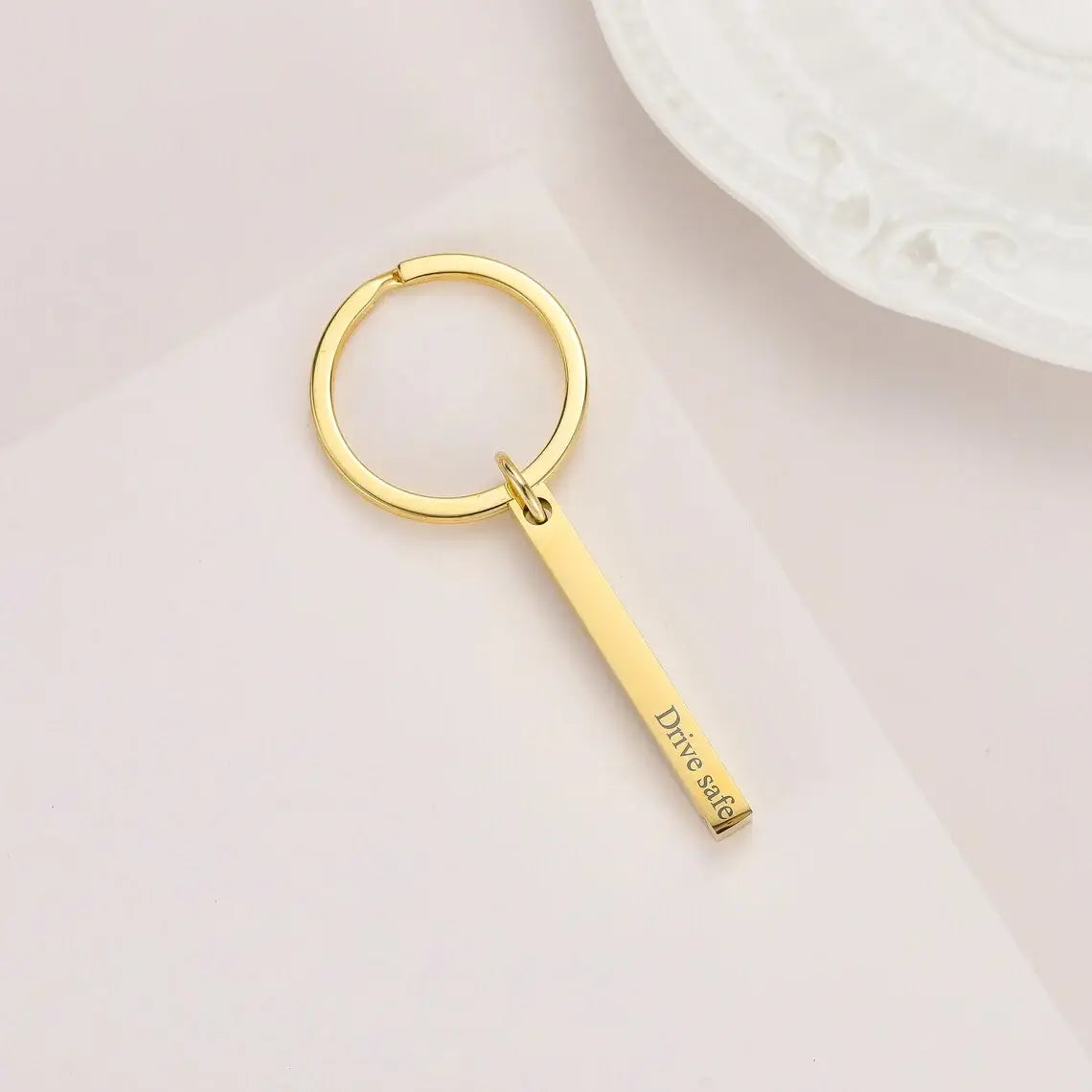 Gold-colored stainless steel custom engraved 4d bar keychain with a rectangular pendant engraved with drive safe.