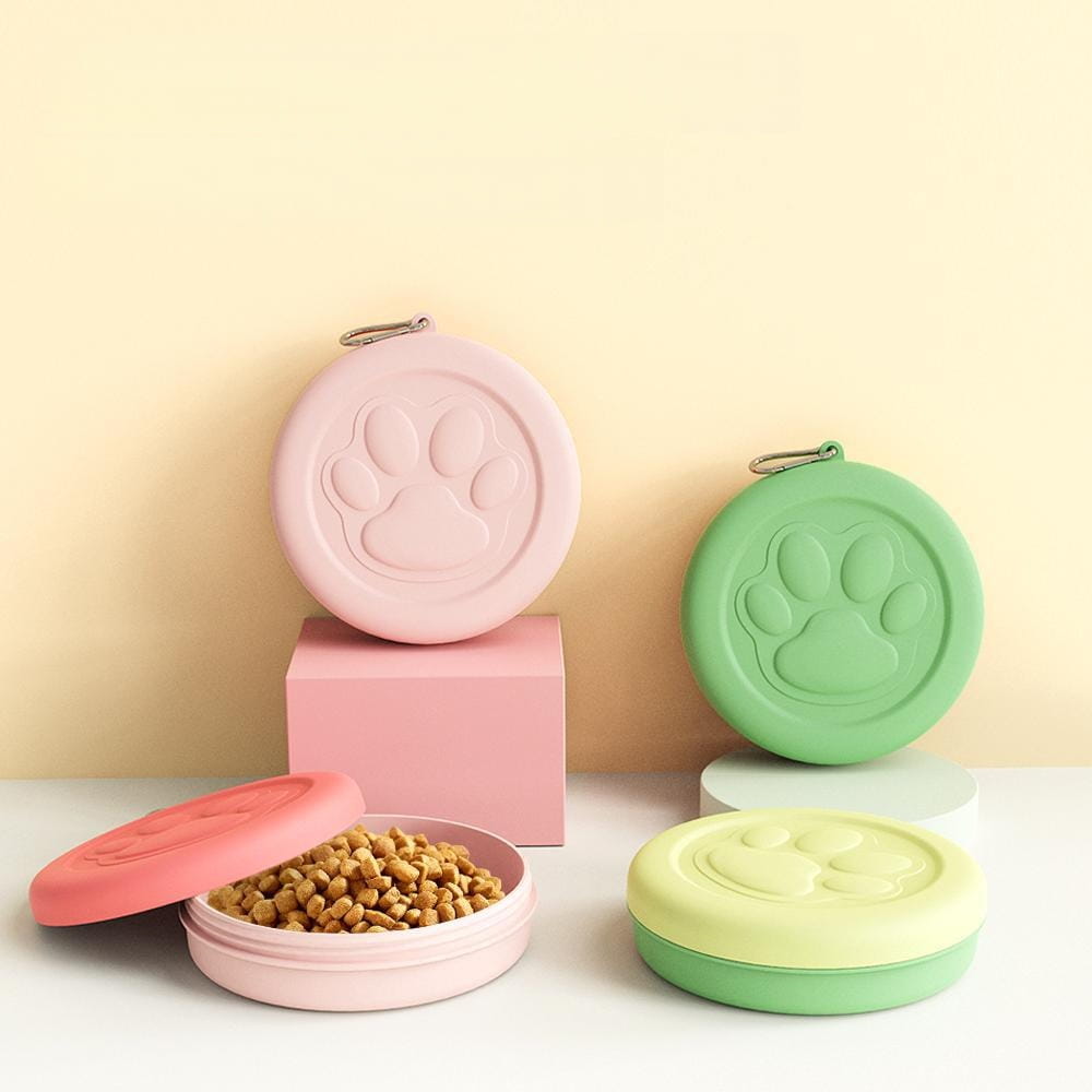 Cuencos portátiles para viajar con perros en tonos rosa pastel y verde, con huellas de pata en relieve que presentan un diseño circular y compartimentos de almacenamiento de golosinas.