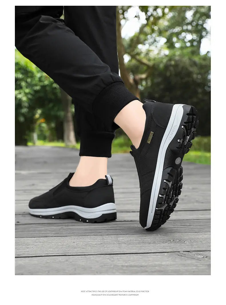 Men orthopedic slip-on black hiking shoe with white midsole and rugged black outsole designed for comfortable walking.