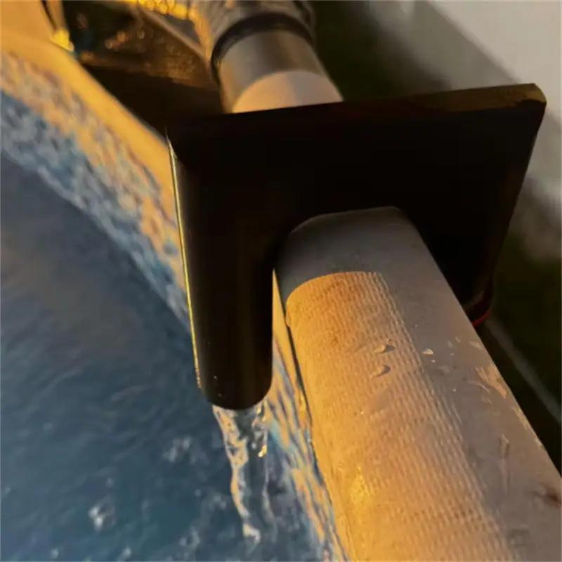 black plastic pipe clamp securing a textured gray hose to a yellowish surface on the back side of a 3d printed pla garden hose water nozzle designed for optimized water flow and made of polylactic acid.