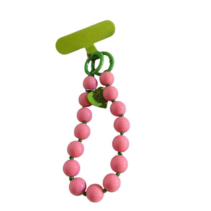 Pink beaded phone wrist strap with green accents and heart-shaped charm shown from front angle