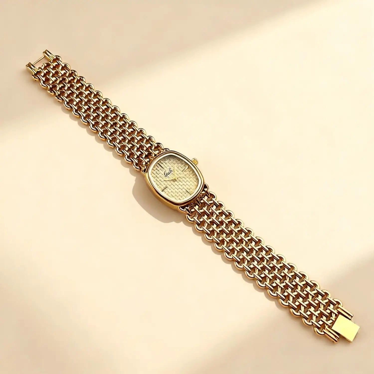Gold-toned mesh bracelet watch for women with a rectangular face, intricate textured dial, and Gucci brand name, an elegant quartz timepiece.