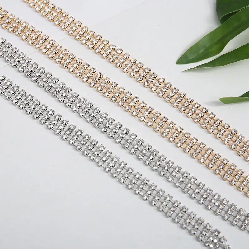rhinestone chain belt for women featuring three parallel rows of adjustable rhinestone trim in gold silver and clear tones as a metal waist accessory.