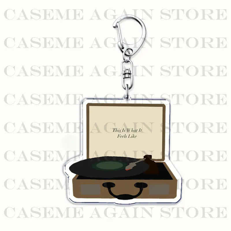 Clear acrylic keychain shaped like an open vintage record player with a black vinyl disc and stylus featuring the text this is what it feels like on its beige inner lid for Gracie Abrams anime fan gift.
