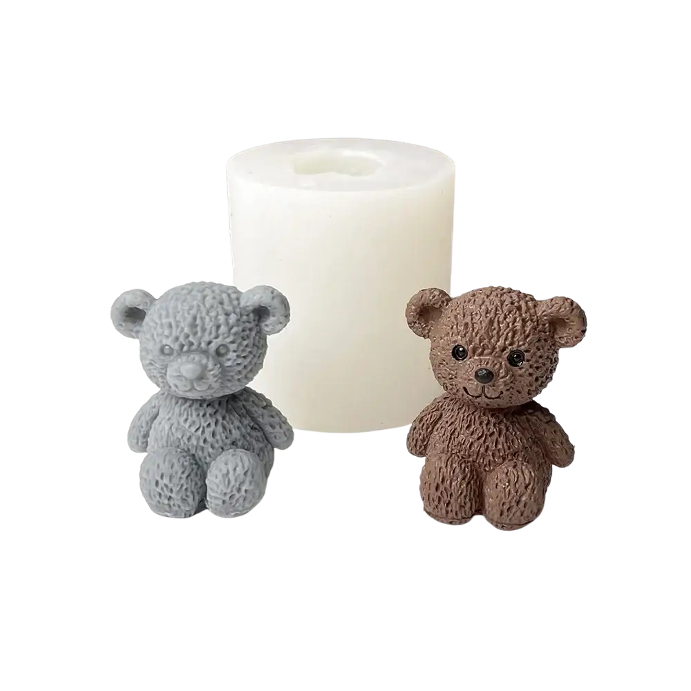 Mini-Teddybär-Kerzenform mit grau- und braun strukturierten Bär-Kerzenformen sowie einer weißen zylindrischen Wachsform im Hintergrund