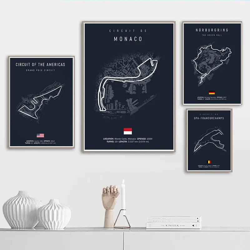 Lot de quatre affiches d’œuvres murales en toile du circuit de Formule 1 encadrées, en bleu marine foncé, avec des illustrations en lignes blanches, représentant Monaco, le Nürburgring, le Circuit des Amériques et Spa-Francorchamps, pour la décoration de la maison dédiée au sport automobile.