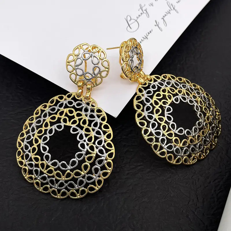 Boucles d’oreilles pendantes en filigrane bicolore or et argent pour femmes, présentant des travaux métalliques en forme de gouttes au motif en filigrane bicolore, complexes et détaillés.