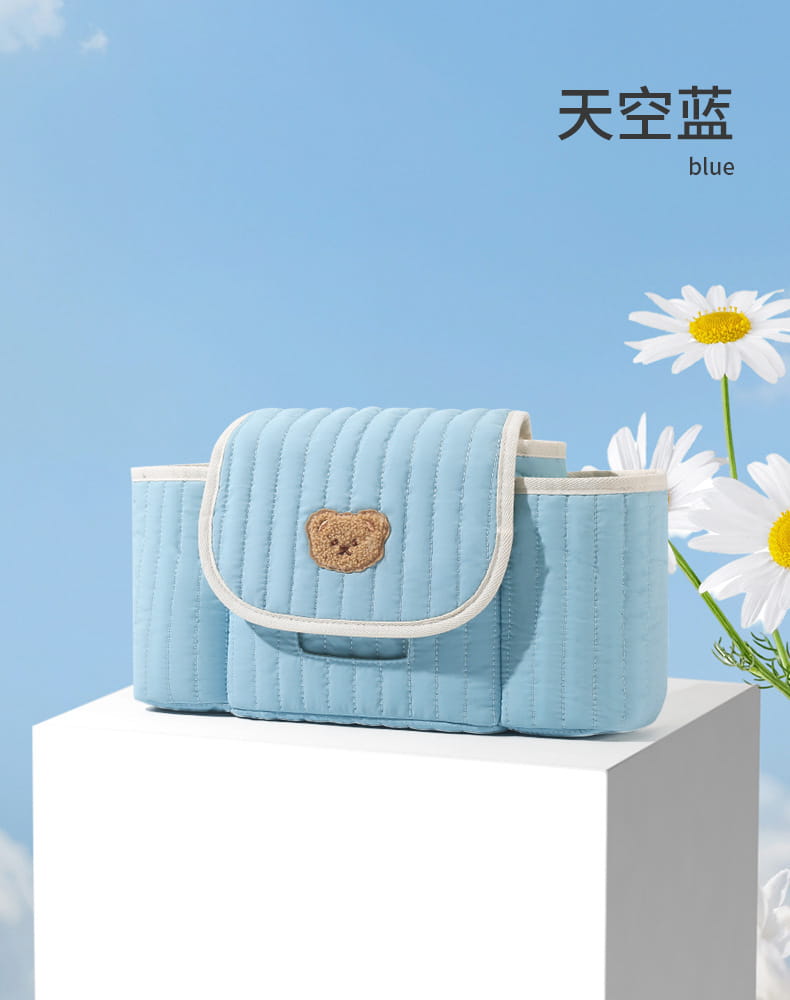 Hellblauer gepolsterter Organizer-Beutel für den Kinderwagen mit beigem Bären-Patch und weißem Besatz.