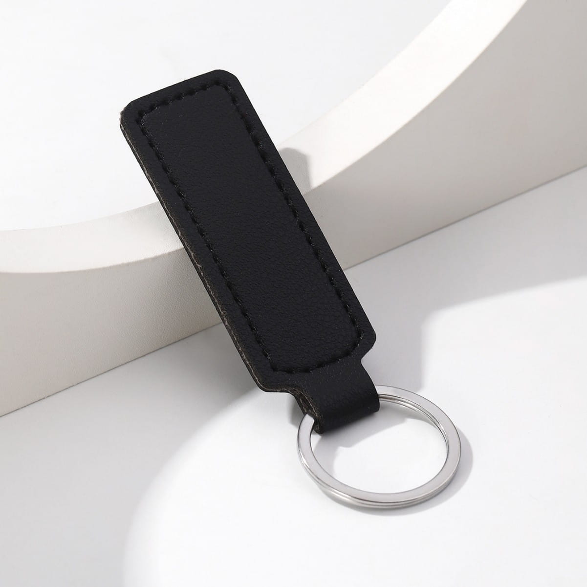 Black leather minimalist strip key ring with a silver metal ring for car keys.