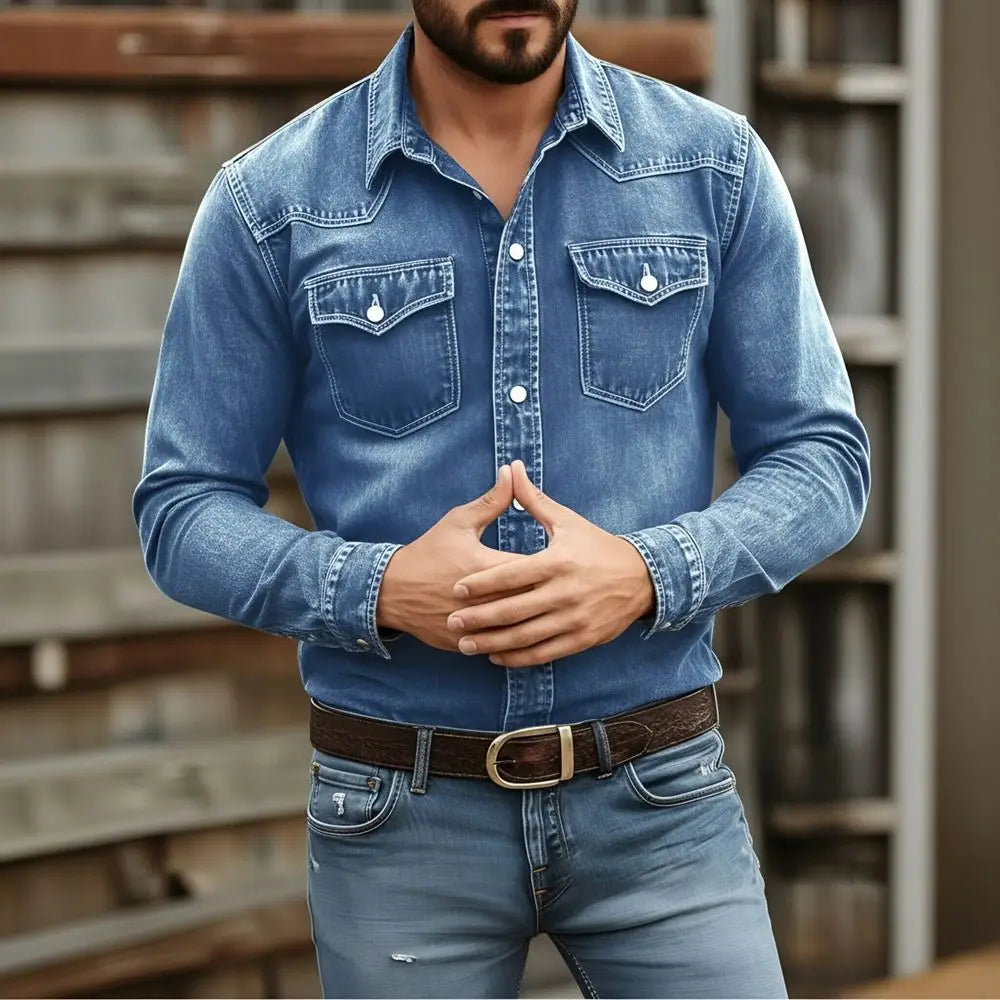 Men’s vintage denim shirt in blue featuring long sleeves, two chest pockets, and white buttons, suitable for casual workwear.