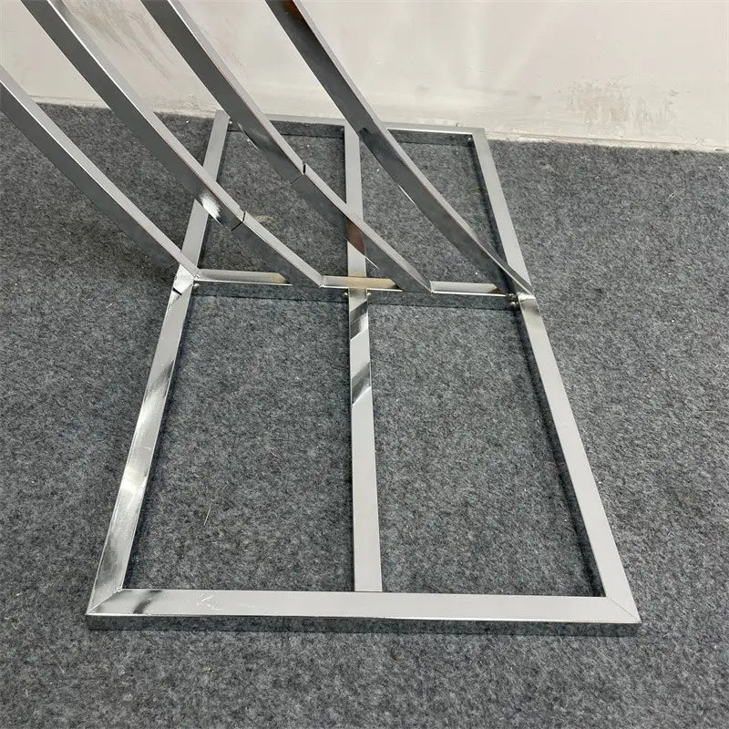 base de table en métal chromé brillant avec un design géométrique moderne comportant des barres incurvées et droites entrecroisées pour servir de support de fond d’arche de mariage dorée pour des réceptions.