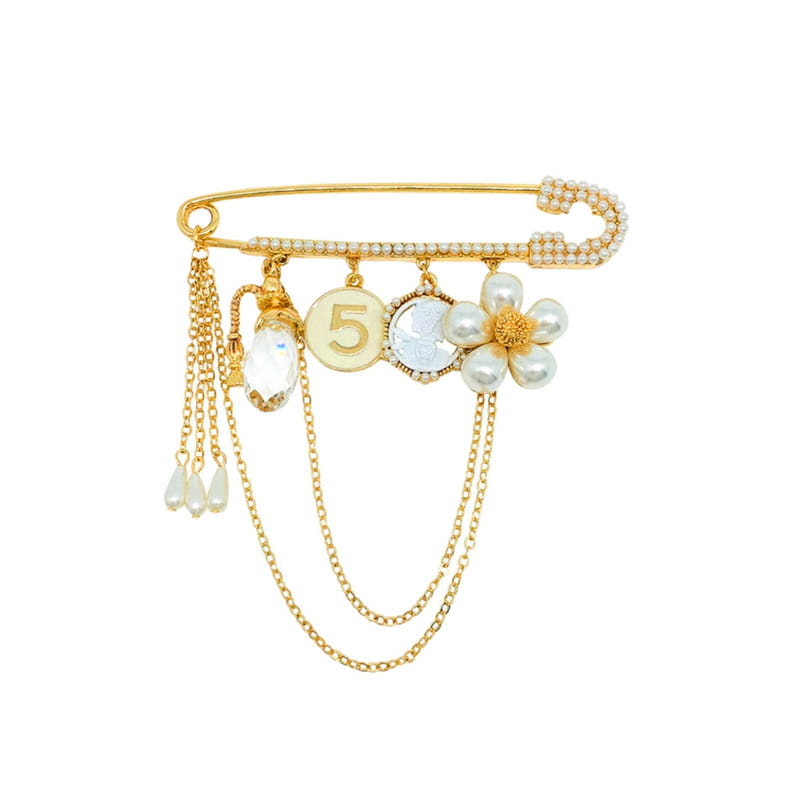 Gold-toned safety pin brooch adorned with pearls crystals and a dangling chain featuring charms including the number 5 and a flower design.