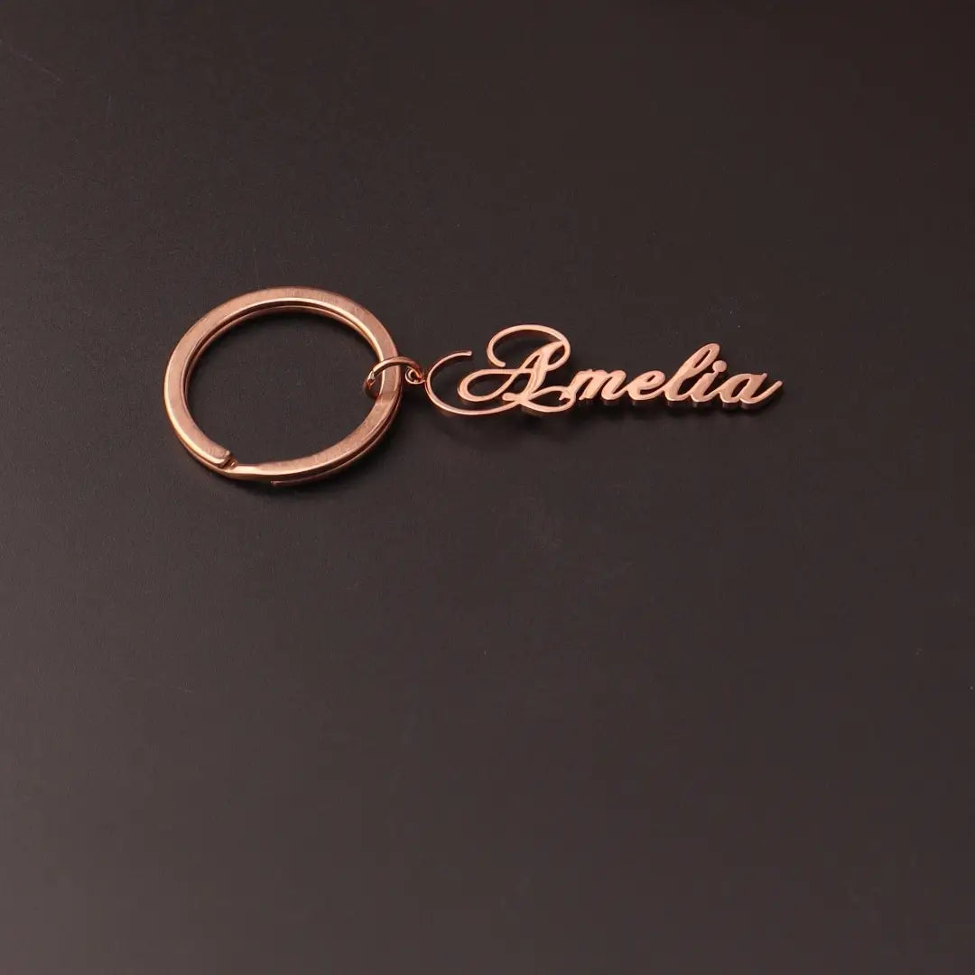 Rose gold-colored custom name keychain made of stainless steel featuring the name Amelia in elegant cursive script designed as a personalized gift.