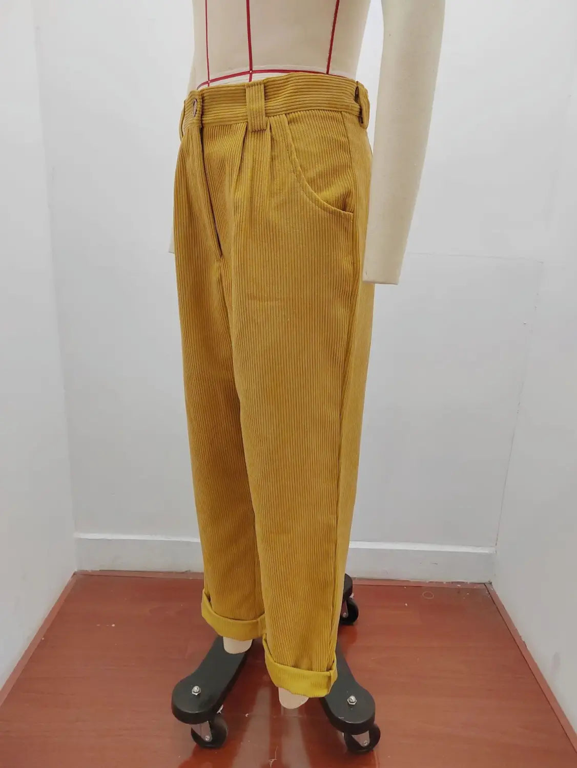 Pantalon en velours côtelé jaune moutarde taille haute ample avec bas retroussés, présenté de face.