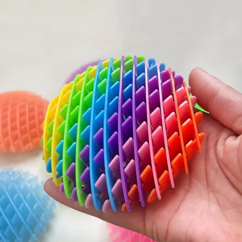 Elastisches Netz-Sinnes-Fidget-Wurmspielzeug mit einem regenbogenfarbenen, gegliederten Stressball mit strukturierter, gerippter Oberfläche aus flexiblem Kunststoff.