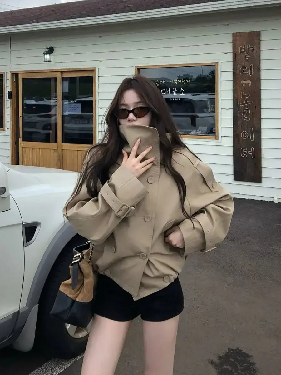 Beige Korean style trench coat utility jacket featuring a double-breasted front and belted cuffs.
