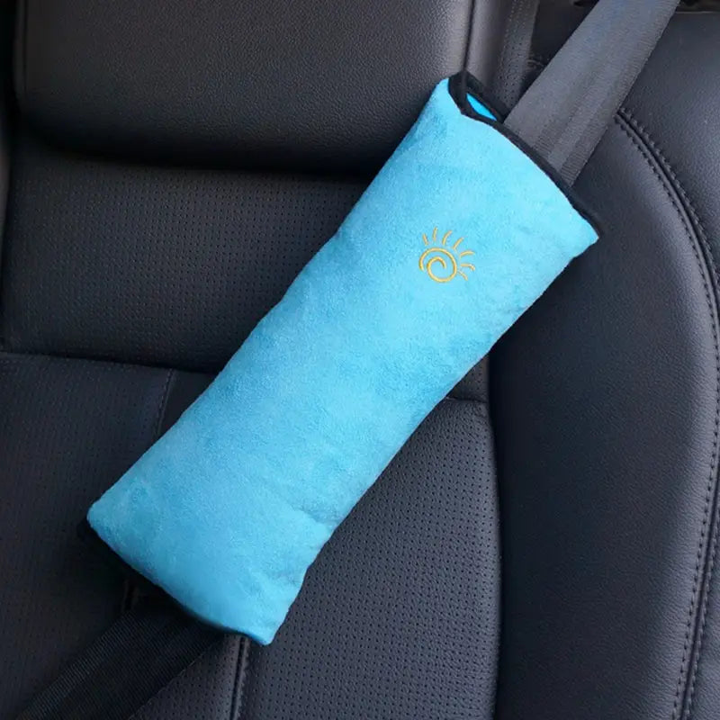 Ein hellblaues Plüsch-Sicherheitsgurtkissen für den Kindersitz mit einem gold bestickten Sonnendesign zur Unterstützung von Kopf und Nacken