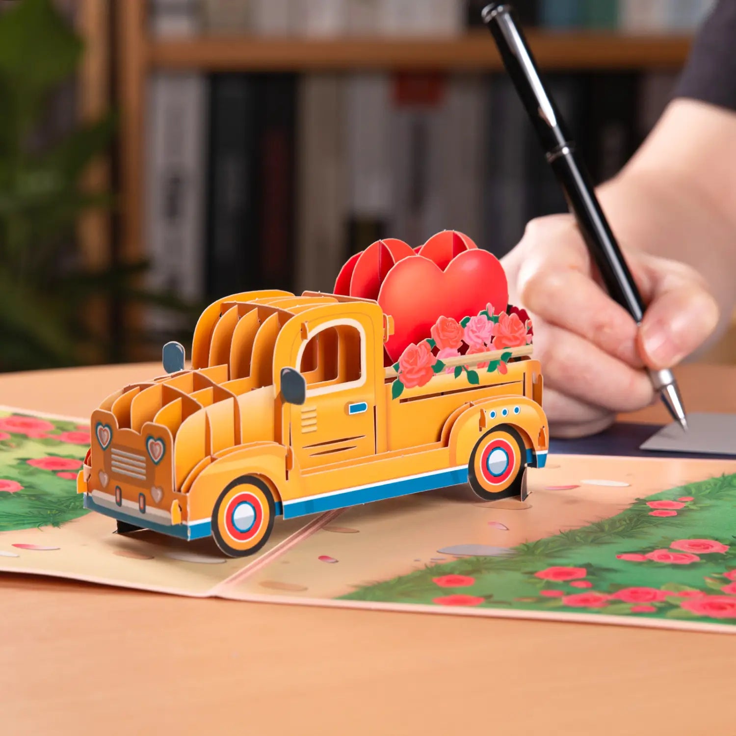 Camionnette pop-up en papier jaune vif avec des accents bleus et des cœurs rouges dans la benne, conçue comme une carte de salutation 3D pour la carte de la Saint-Valentin 3D à effet pop-up, ensemble de salutations en couple romantique.