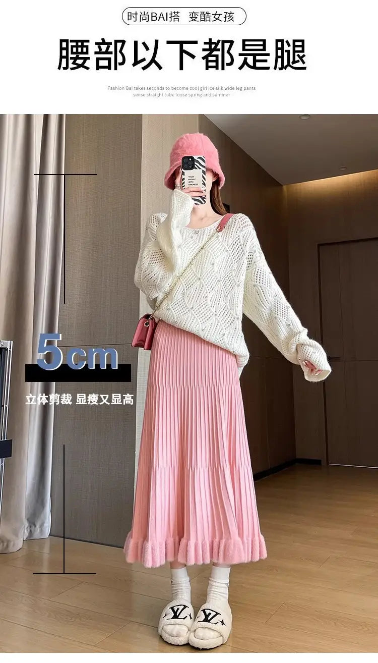 Jupe mi-longue en maille rose, avec taille haute et design parapluie à plis, illustrée du côté arrière