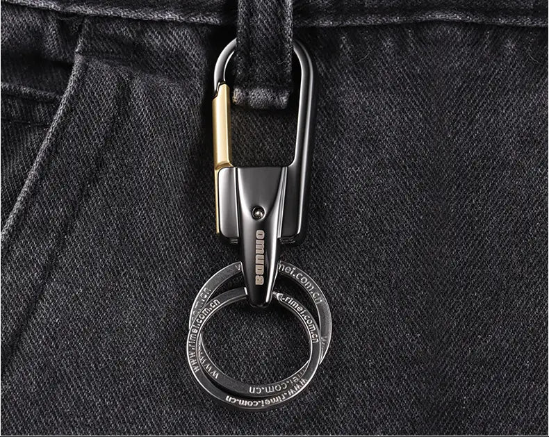2つのかみ合わせ式リングを備えた、ステンレス製ブラックおよびゴールド回転式カーキーチェーン（カラビナ付き）。