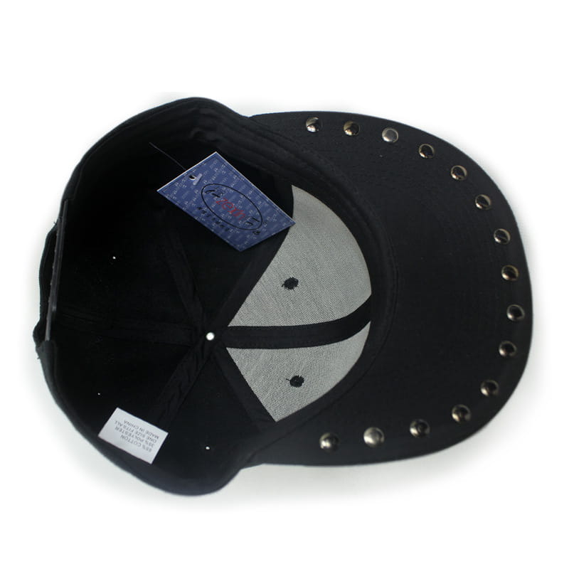 Black sugar skull rivet snapback baseball cap with silver-toned metal studs along the brim and a gray mesh panel on the back side.
