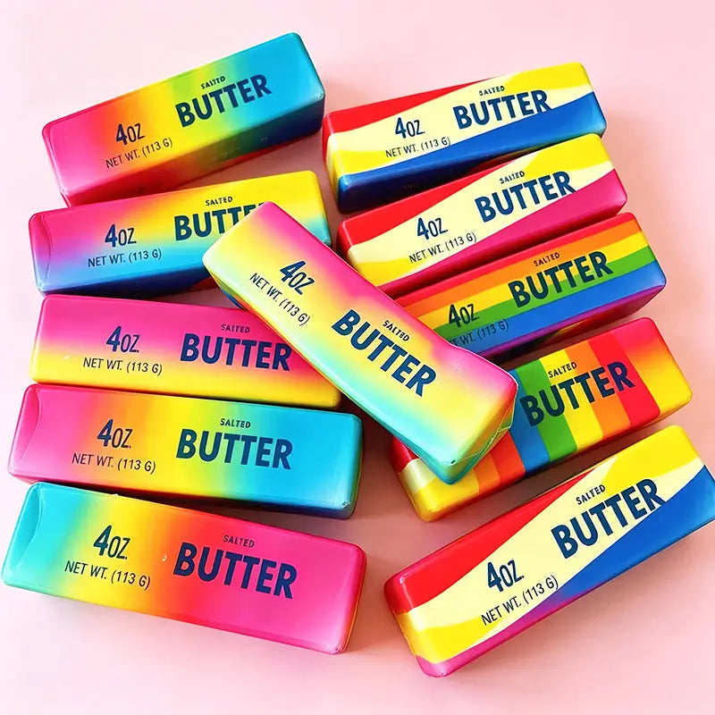 Rainbow butter squishy stress relief toys shaped like salted butter sticks feature rainbow-colored gradient packaging with bold blue lettering for a vibrant design.