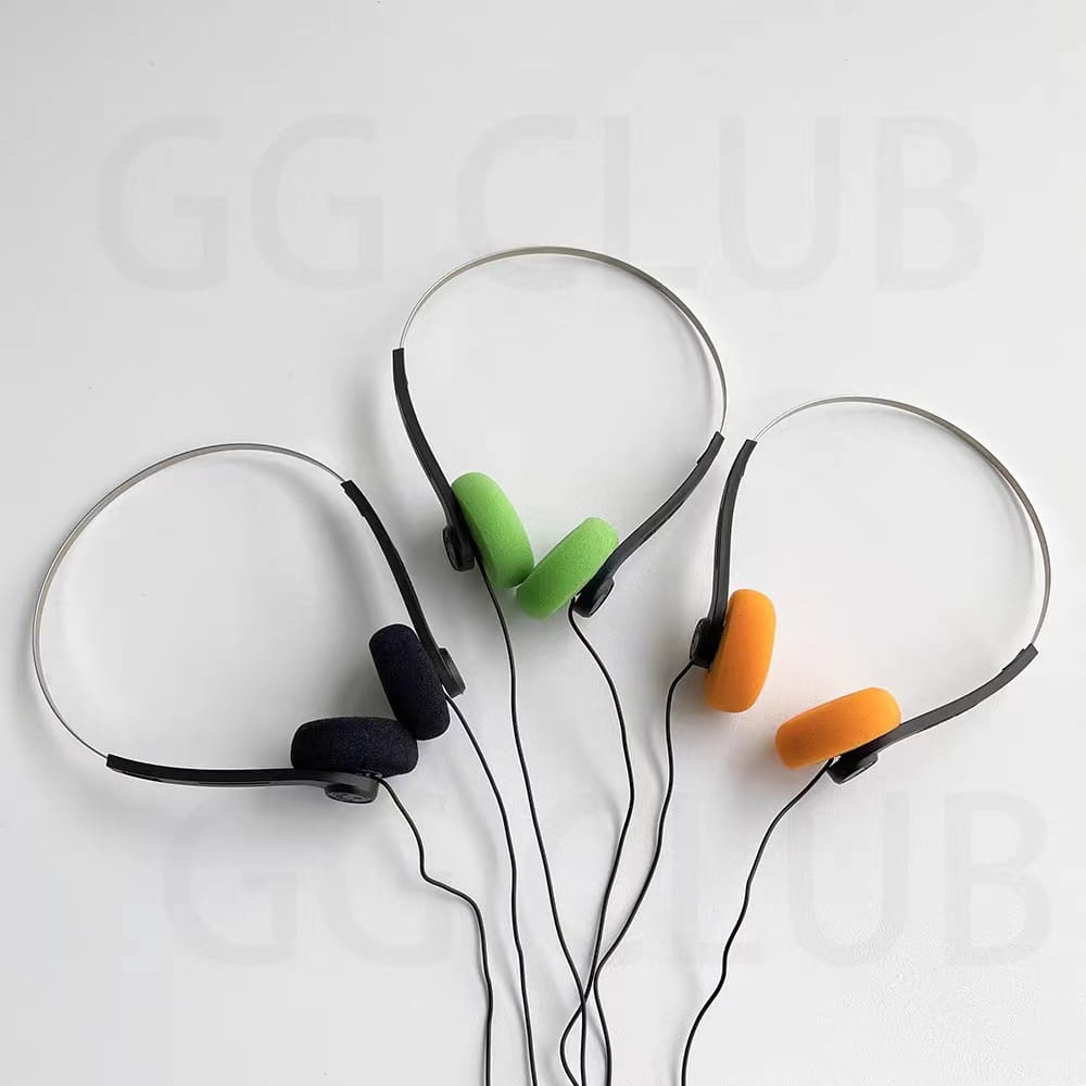 Drei Paar kleine Kopfhörer mit schwarzem Over-Ear-Design und farbigen Schaumstoff-Ohrpolstern in Grün, Orange und Marineblau für den retro-kabelgebundenen, tragbaren Einsatz.