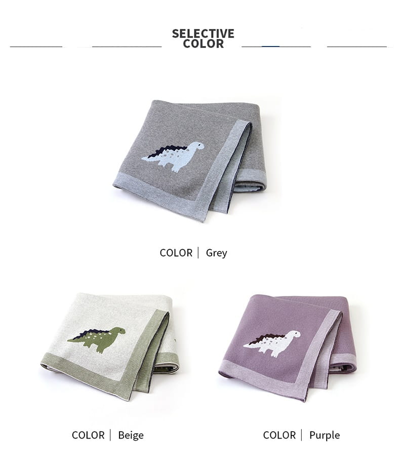 Grau-beige und lila Kinderbadetücher mit weicher Strickstruktur und bestickten Dinosaurierdesigns aus der Kollektion „Dinosaur Knit Baby Blanket“ Baumwoll-Wickeldecke für das Gitterbett.