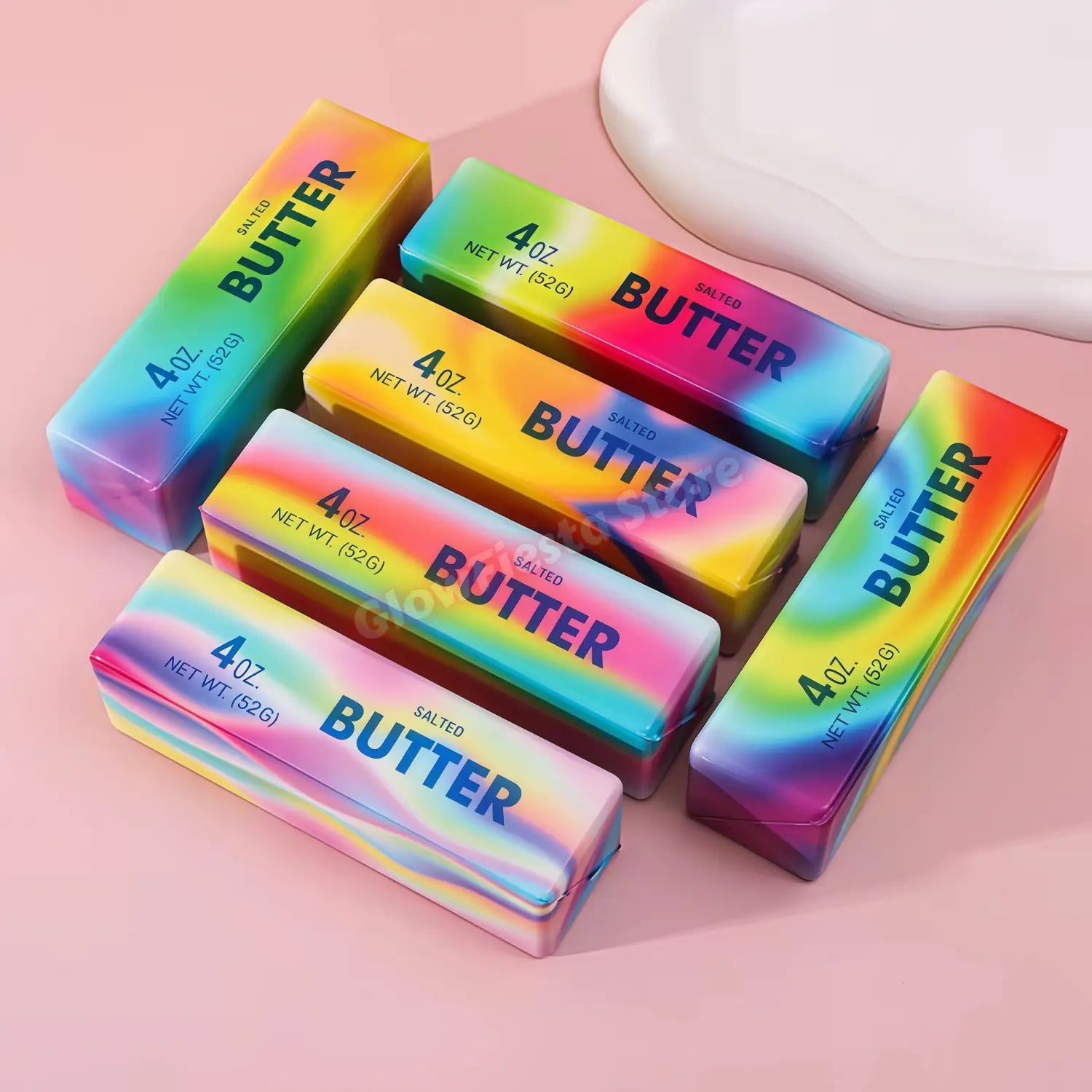 Barres de bâton de beurre salé aux couleurs de l’arc-en-ciel, enveloppées dans un plastique irisé brillant, avec un texte noir audacieux, conçues comme des jouets antistress à montée lente, en assortiment de 12 pièces.