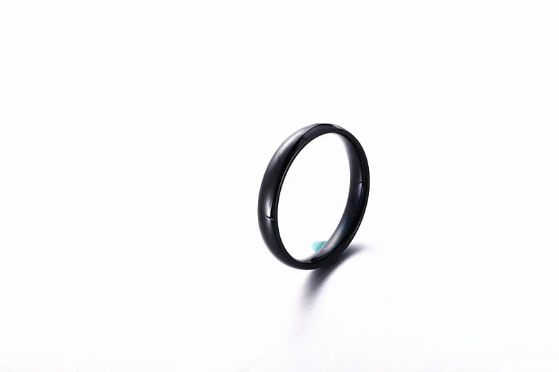 black ceramic wedding band with a smooth glossy finish and subtle beveled edges shown alongside a stainless steel rose gold wedding band 6mm ring