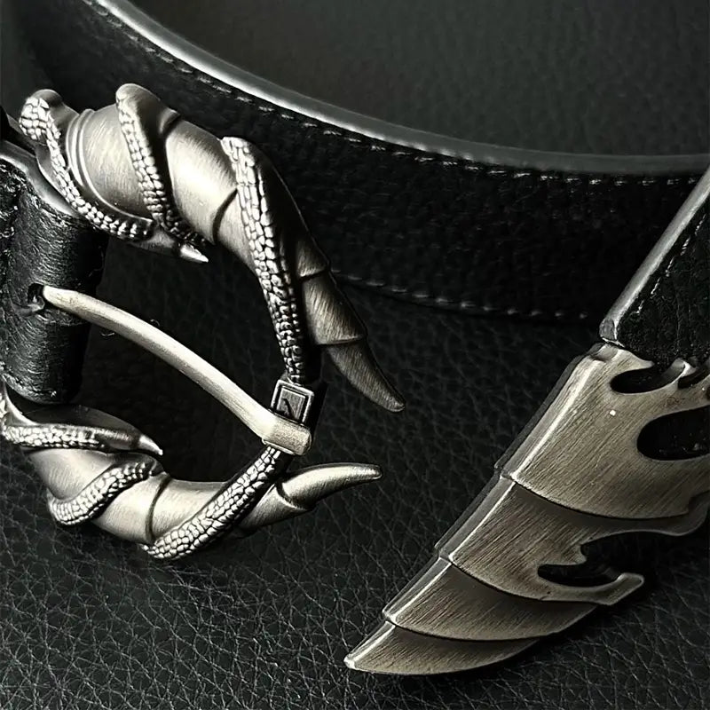 A detailed silver-toned metal belt buckle shaped like a claw with textured ridges and sharp talons gripping a leather strap for plus size y2k decoration.