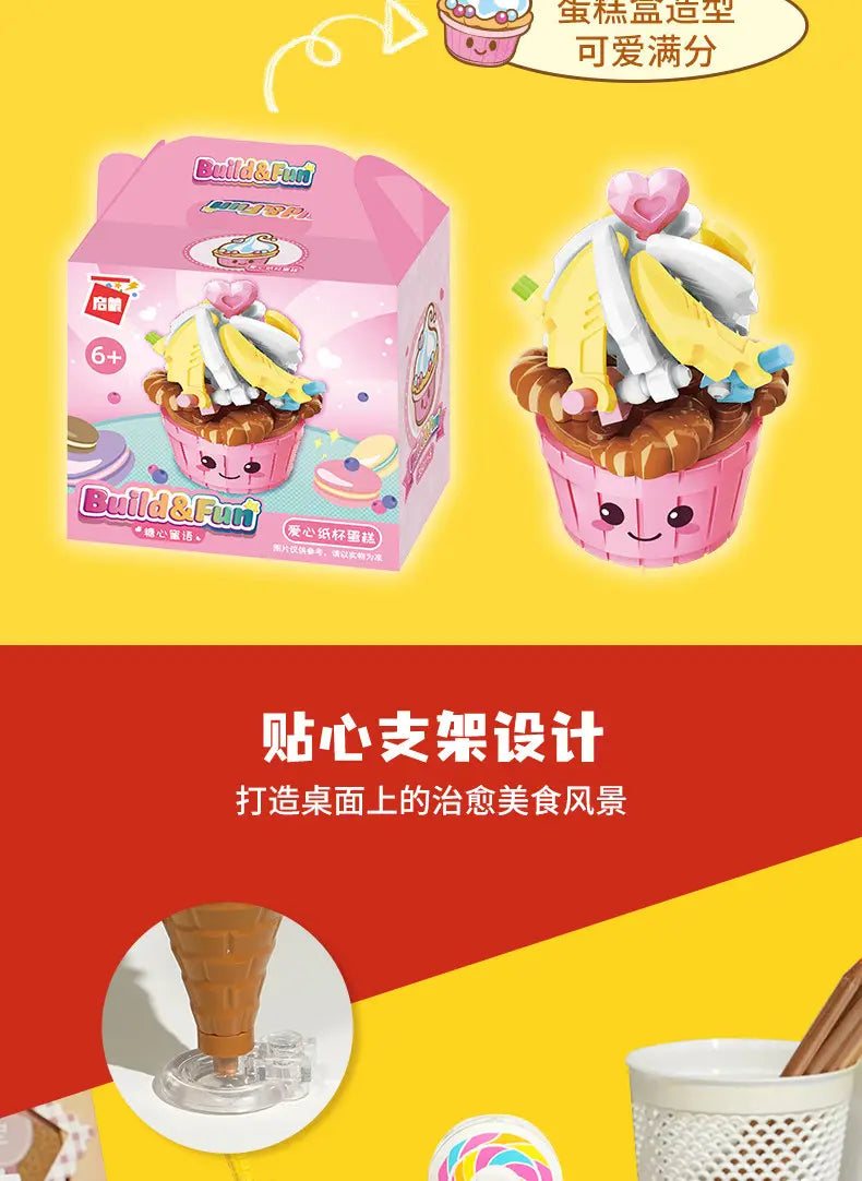 黄色と白のフロスティング、チョコレートの土台、上部のピンクのハートを備えた、ピンクのカップケーキ形の玩具を特徴とするファストフード・マイクロビルディングブロック玩具セット